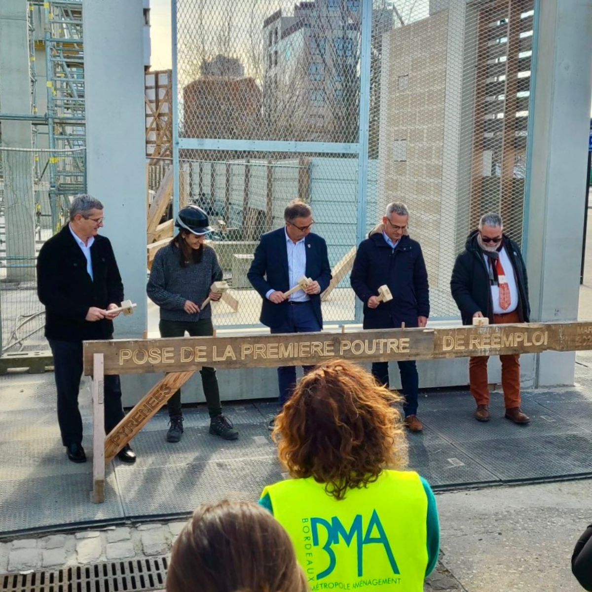 Pose de la première poutre de bois de réemploi du futur préau sportif des Bassins à Flot